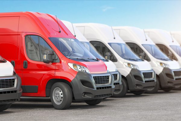 Red delivery van in a row of white vans. Best express delivery and shipemt service concept.